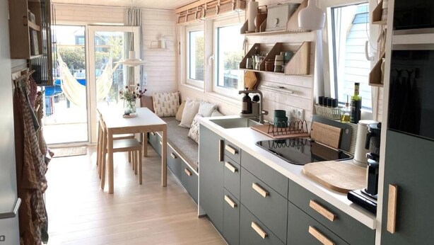 A modern kitchen with a central island, built-in cabinets, and a large window providing natural light.