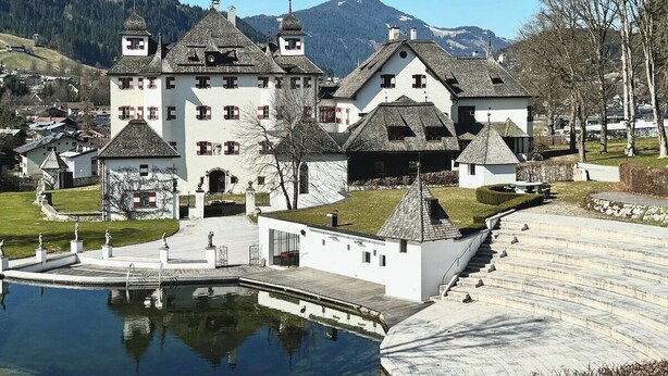 Ein großes, weißes Gebäude mit mehreren Türmen und einem Pool im Vordergrund.