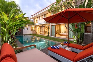 A modern house with a swimming pool, outdoor seating, and lush greenery. - Beautiful Boho-chic 4br Tropical Villa in Pererenan Canggu (Canggu)