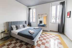 Een moderne slaapkamer met een geruit vloerkleed, een bed met een grijze hoofdbord en een nachtkastje.