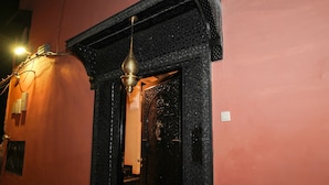 A doorway with intricate black carvings and a hanging brass light fixture. - Riad Roummana Marrakech (Marrakech)
