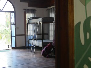 A room with a bunk bed, a ladder, a window with curtains, and a door leading outside. - Hotel Mandacaru Puerto Viejo (Cahuita)