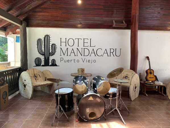 Una batteria in una stanza con soffitto in legno e un cartello con la scritta Hotel Mandacaru a Puerto Viejo.