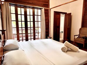 A room with a bed, a chair, and a view of the outdoors through a window. - Hotel Mandacaru Puerto Viejo (Cahuita)