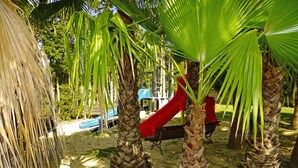 Un parque infantil con toboganes y palmeras.