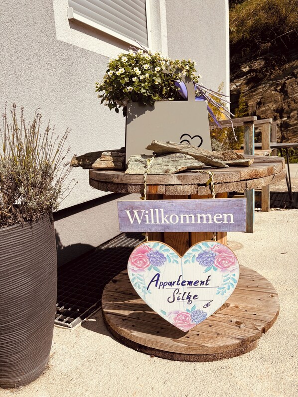 Un letrero de madera con la palabra 'Willkommen' y 'Appartement Silke' sobre un soporte de madera.