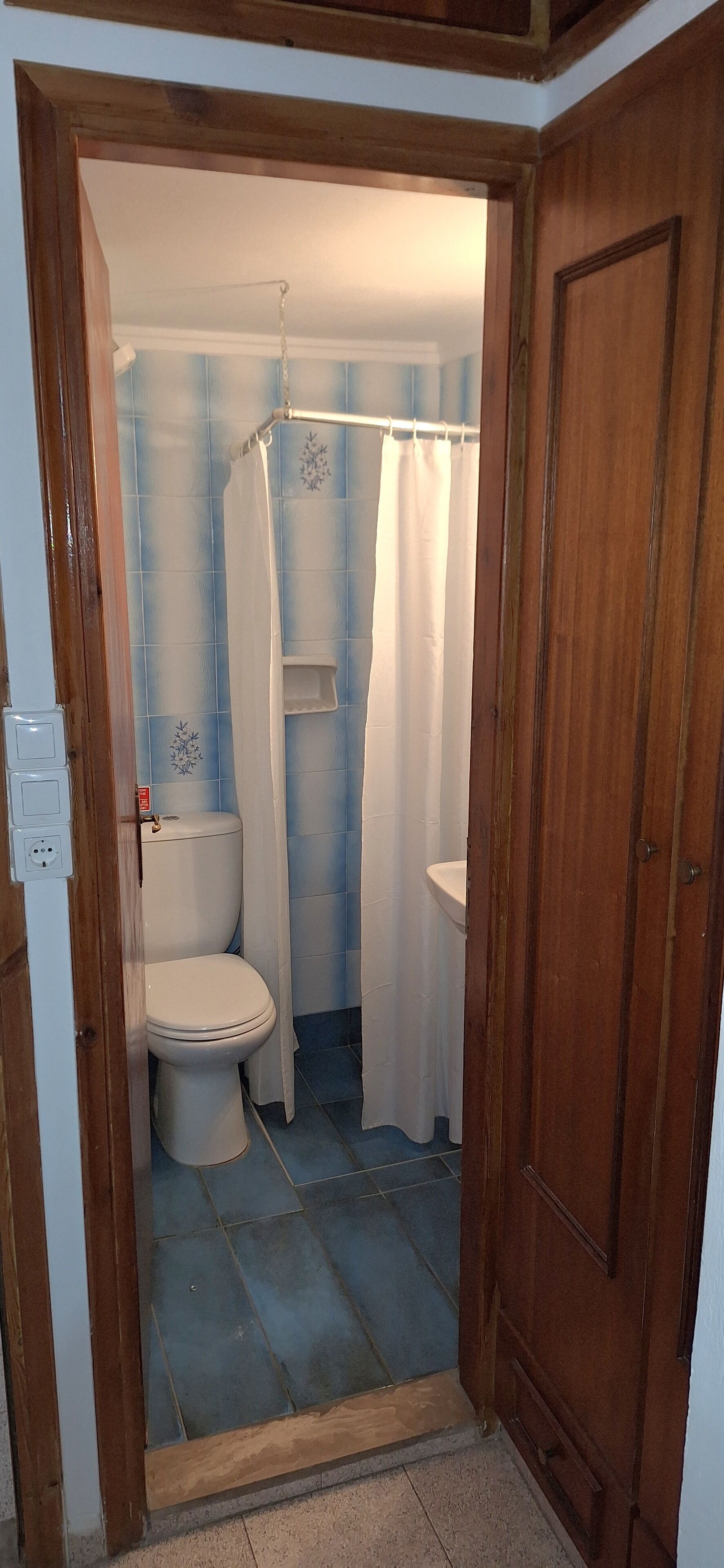 A bathroom with a toilet, a sink, and a shower curtain.