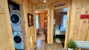 A wooden interior with labeled rooms: 'ADIRONDACKS', 'WHITEFACE', and 'LOOKOUT MTN'. A washing machine is visible in the 'ADIRONDACKS' room. - Stylish Mountain Retreat: Hot Tub, Fire Pit, Whiteface Views! (Wilmington)