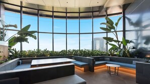 A modern interior with a curved ceiling, large windows, and seating areas.