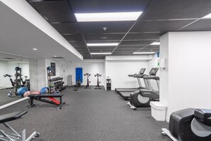 A gym with treadmills, weight machines, and exercise balls.