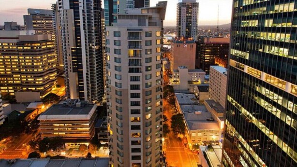 A high-rise building with multiple floors, surrounded by other tall buildings. - Discover Urban:1BR|Pool|Gym|Sauna|Convenient (Brisbane City)