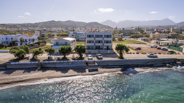 A coastal town with buildings, a beach, and mountains in the background. - Alexia Seaview Apartments  (Kissamos)
