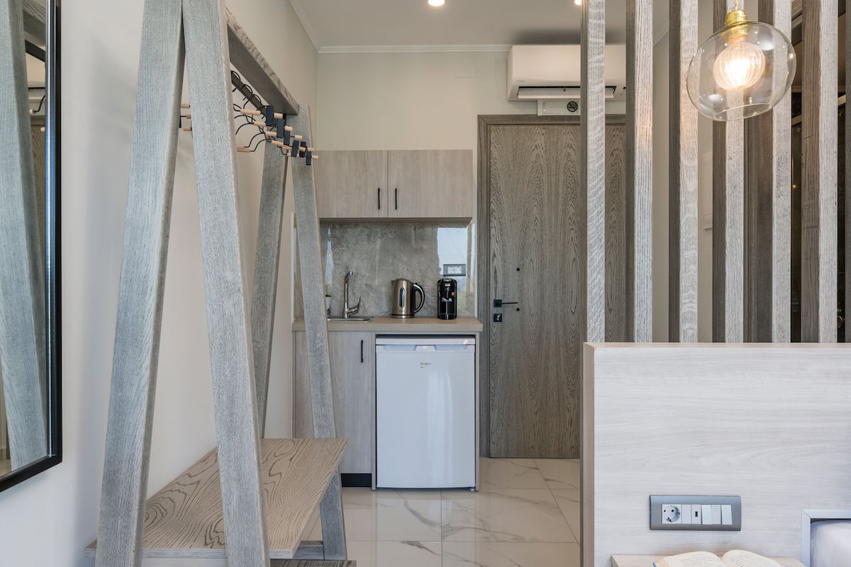 A modern kitchen with a dishwasher, a coffee maker, and a wooden cabinet.