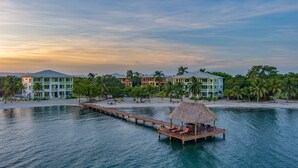 A resort with a water dock, beach, and multiple buildings. - Beach Walkout Condo 112 3BR/2BA Sleeps 8 (Placencia)