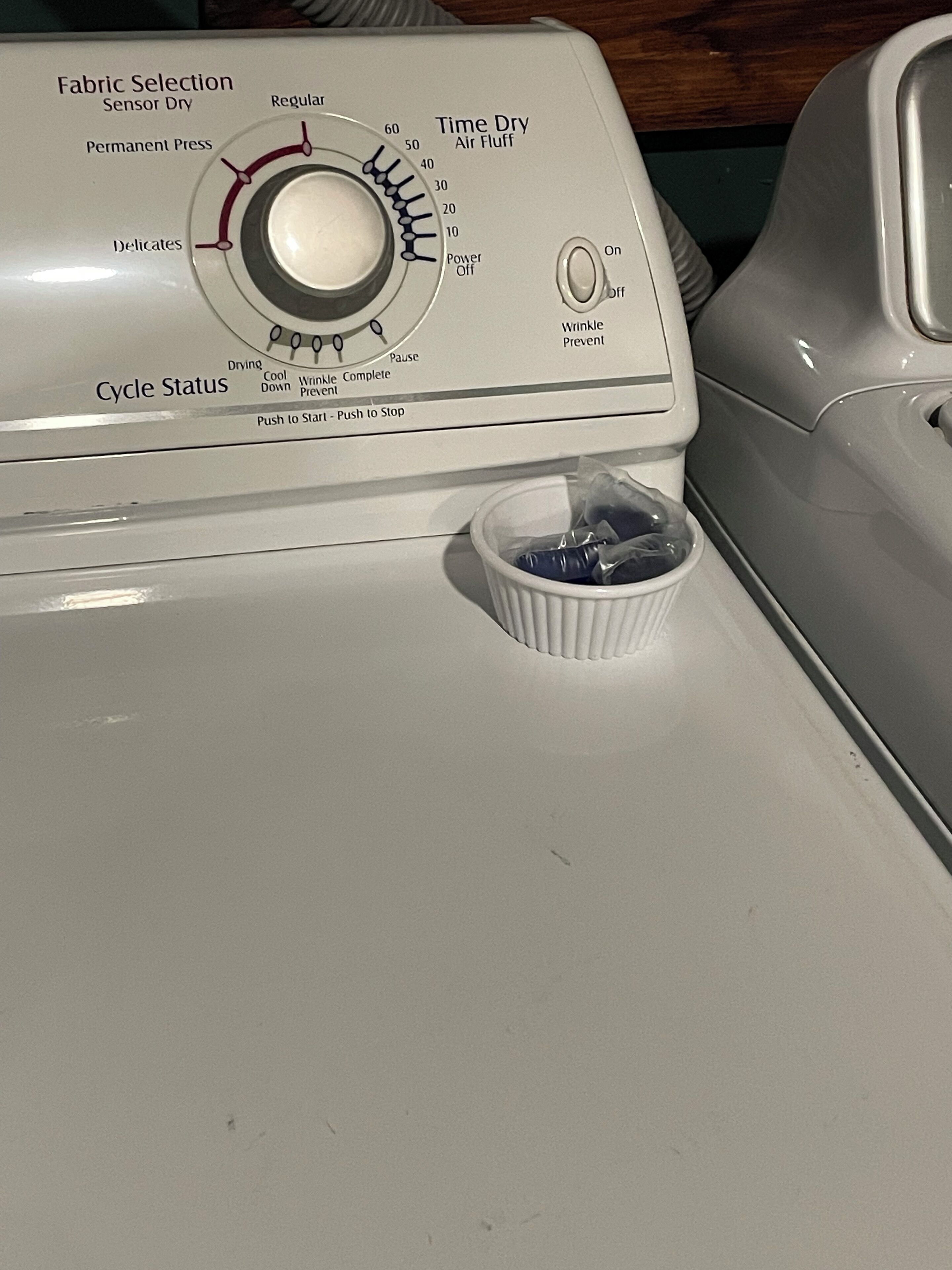 A washing machine with a dial for fabric selection and cycle status.