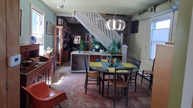 Uma cozinha ampla com área de jantar, escada e sala de estar.