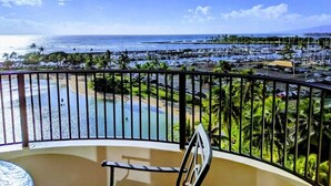 Un balcón con vistas a un puerto deportivo, playa y océano.
