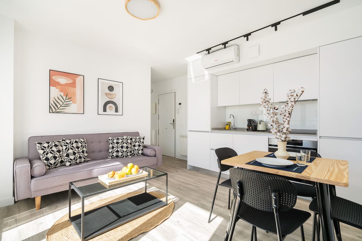A modern living room with a sofa, coffee table, and artwork on the wall.