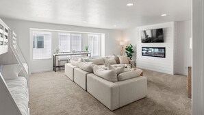A modern living room with a sectional sofa, a dining area, and a fireplace.