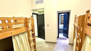 A corridor with bunk beds, a door, and a view into another room. - Lakeside Hostel Downtown (Dubai)