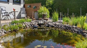Relax by the serene pond surrounded by lush greenery and enjoy the peaceful atmosphere.