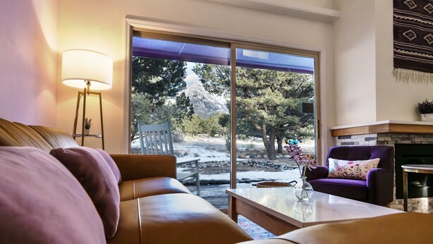 A cozy living room with a sofa, a coffee table, and a fireplace.