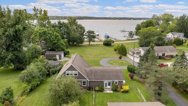 A residential area with houses, a lawn, and a lake with boats.