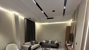 A modern living room with a marble floor, a sofa set, a coffee table, and a TV stand. - Farida Palace Hotel Boutique  (Luxor)