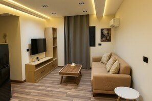 Luksus-studiosuite | Oppholdsområde | En 40-tommers Flatskjerm-TV med kabel-kanaler