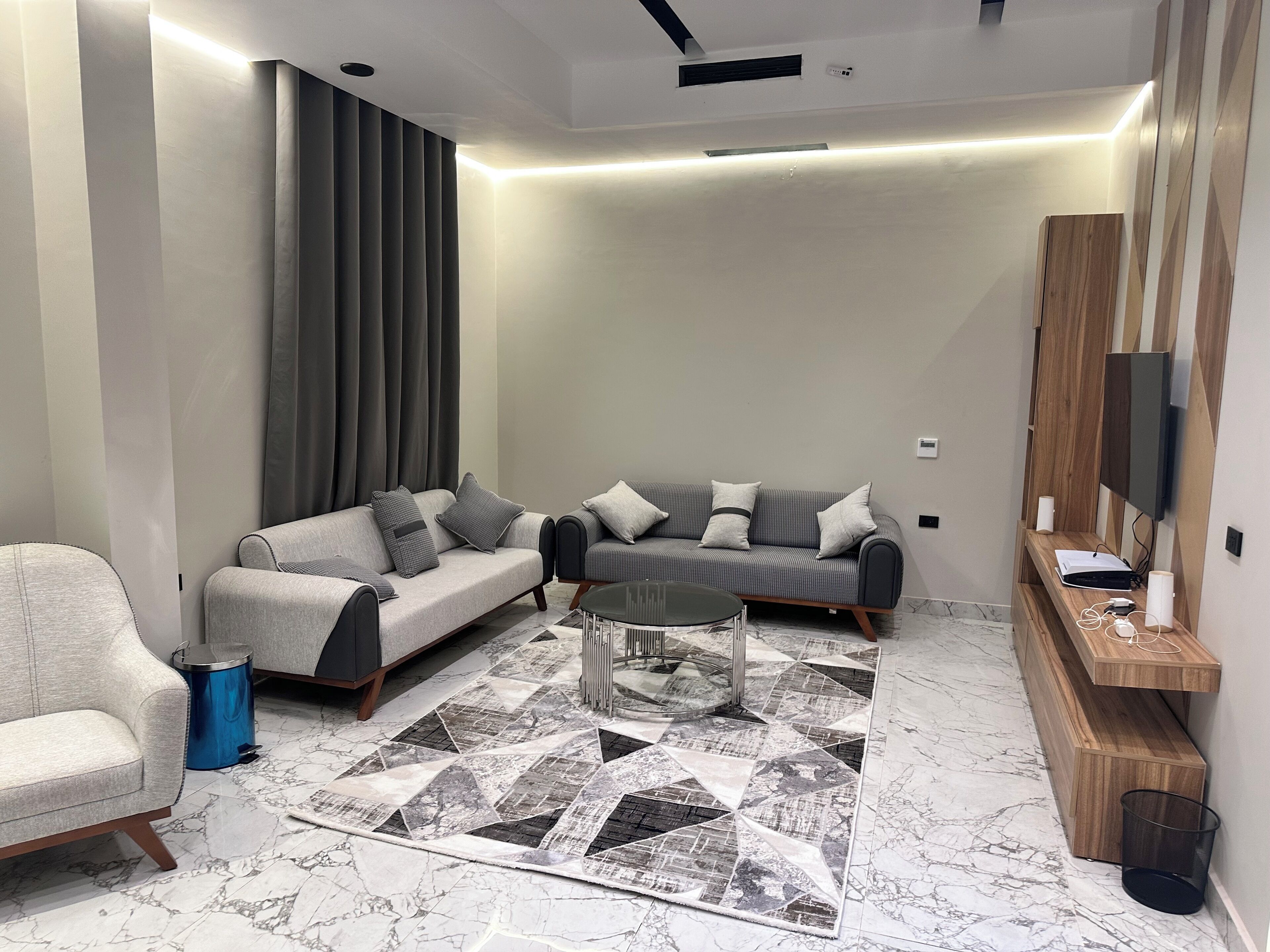 Een moderne woonkamer met een bank, fauteuil en salontafel.