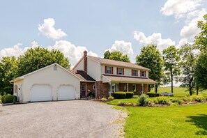 A two-story house with a garage, a covered porch, and a well-maintained lawn. - Twin Ridge Retreat (Port Royal)