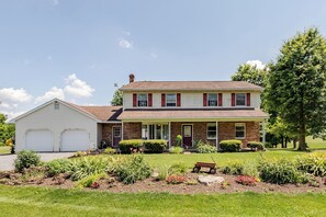 A two-story house with a garage, a front porch, and a well-maintained garden. - Twin Ridge Retreat (Port Royal)