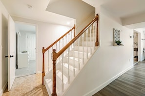 A staircase with wooden balusters and a white handrail leading to an upper floor. - Twin Ridge Retreat (Port Royal)