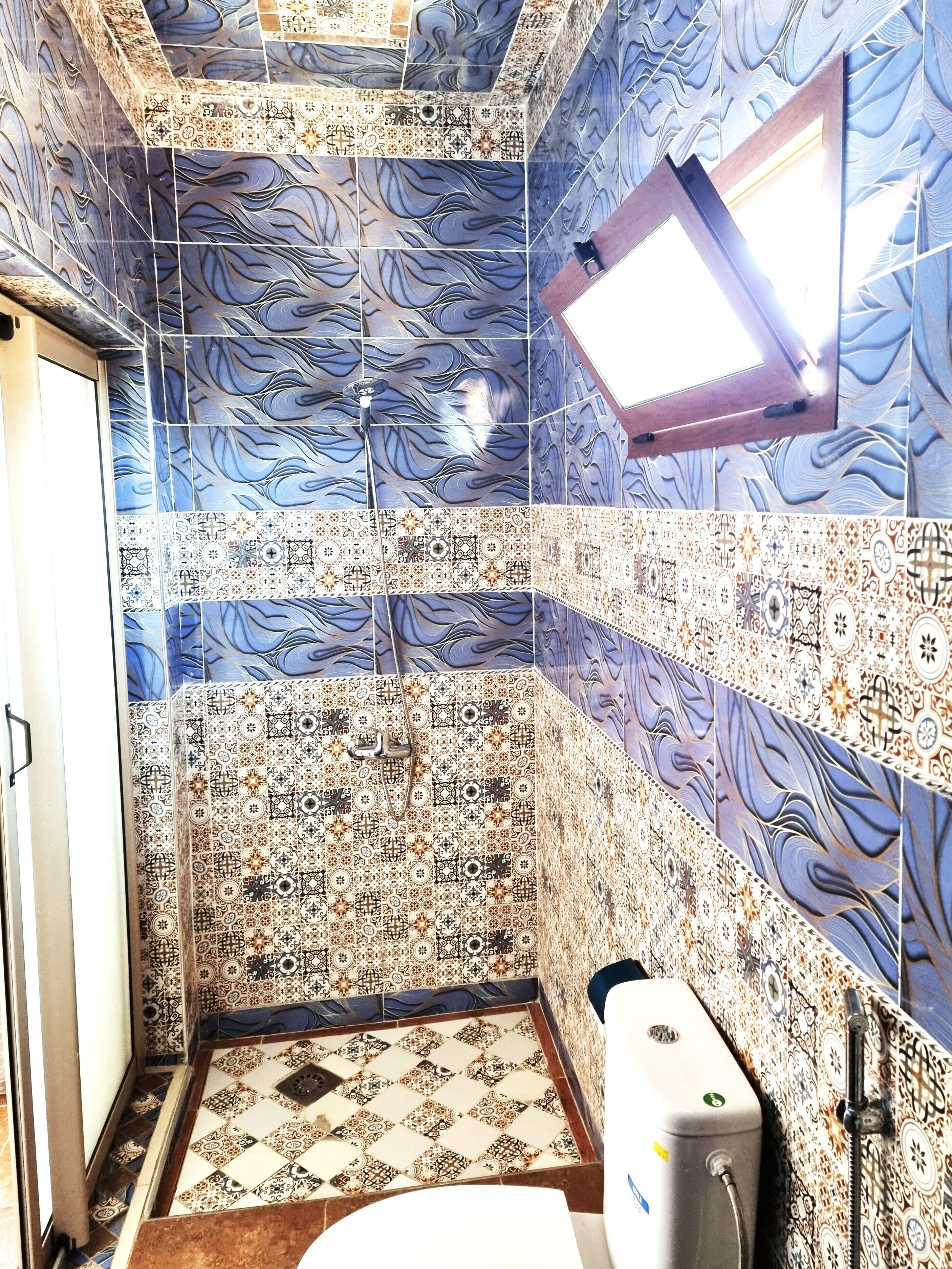 Baño con ducha, inodoro y lavamanos.