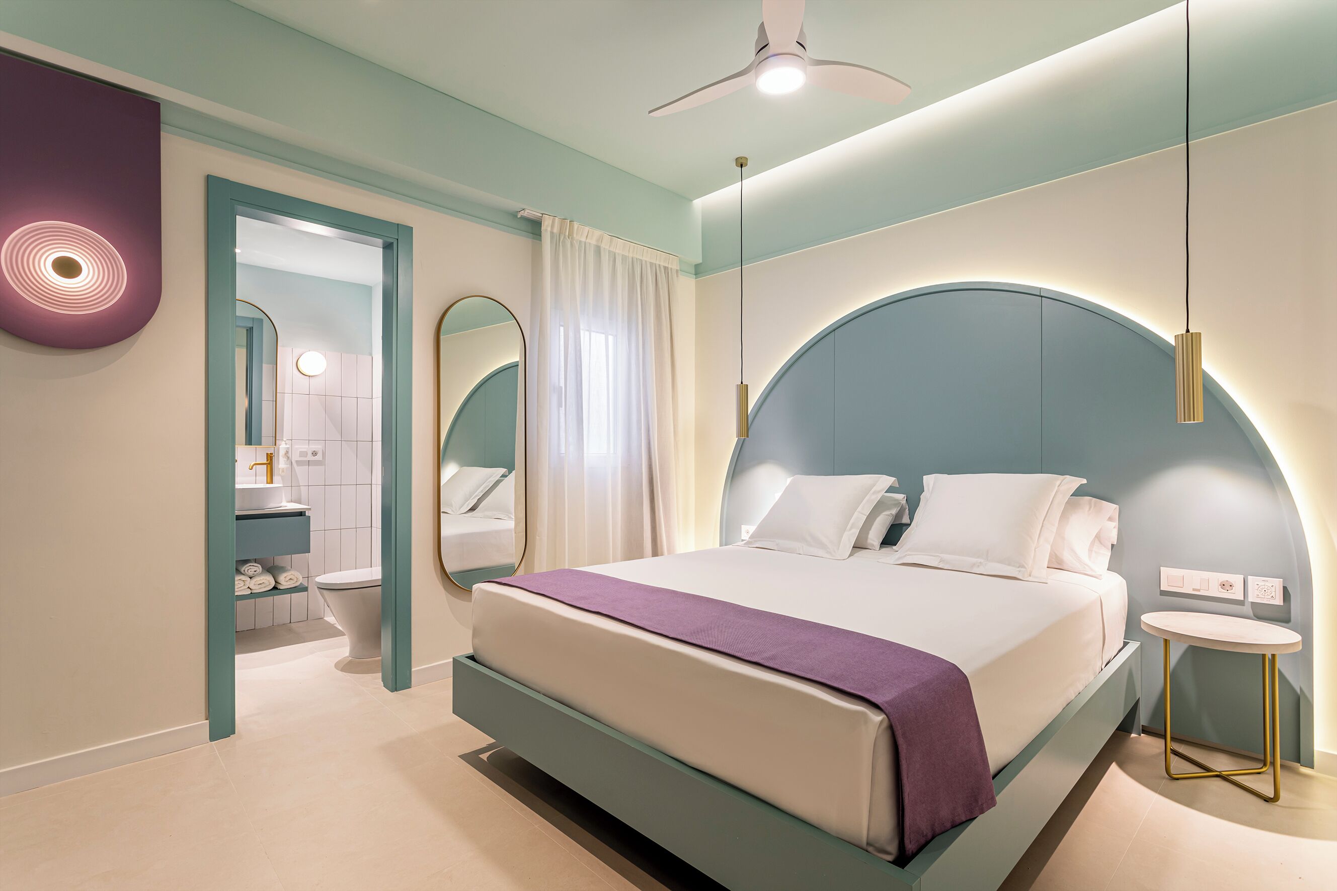 A modern bedroom with a bed, bedside table, and a ceiling fan.