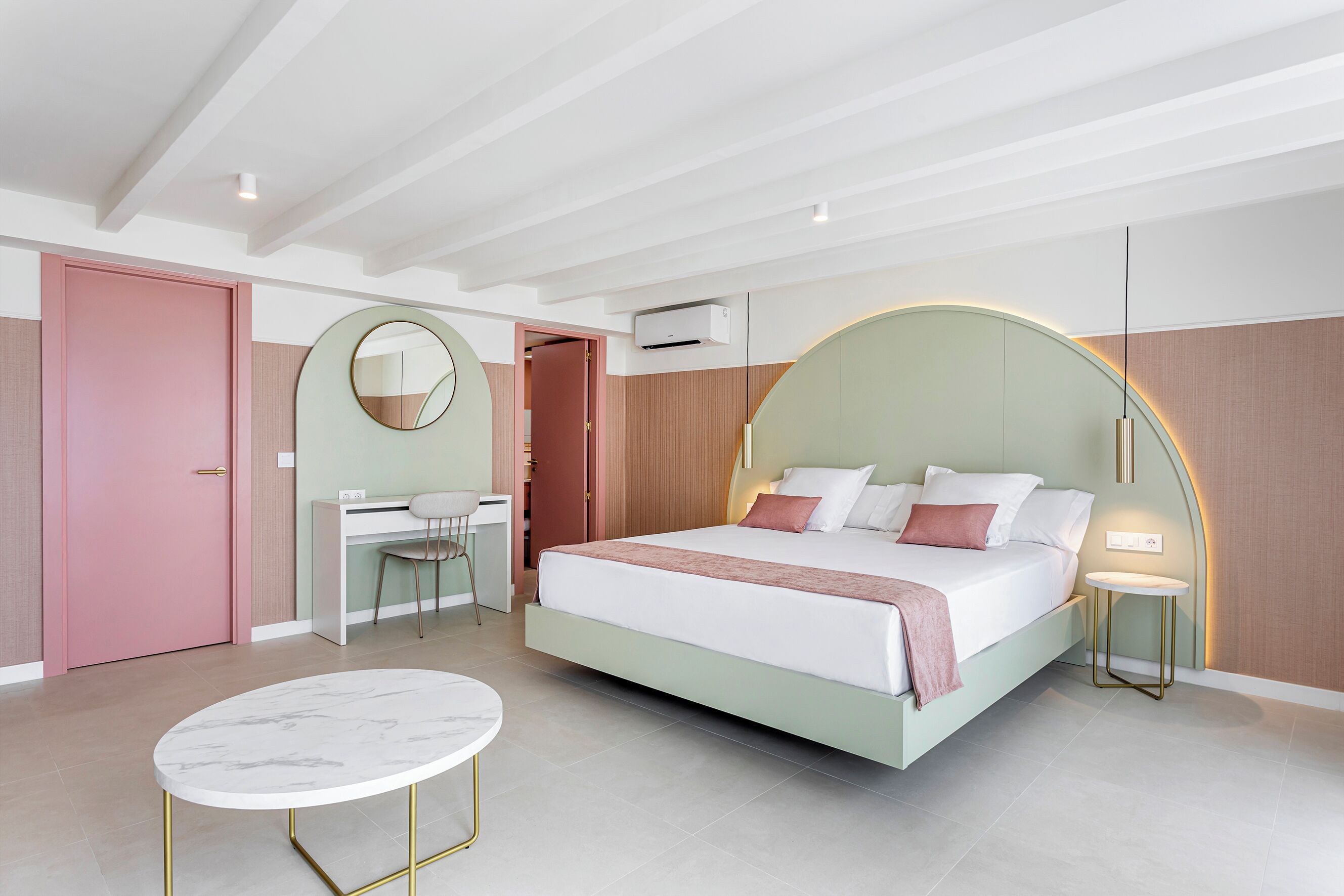 A modern bedroom with a bed, desk, chair, and a round table.