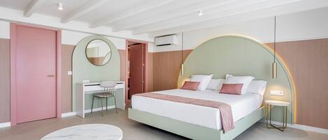 A modern bedroom with a bed, desk, chair, and a round table.