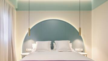 A modern hotel room with a large bed, two bedside tables, and a unique arched ceiling design.