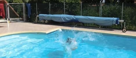 Una piscina con una persona sumergiéndose en el agua.