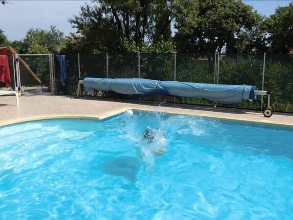 Una piscina con una persona sumergiéndose en el agua.