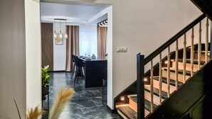 A modern interior with a staircase, a dining area, and a kitchen.