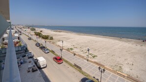 A beachside view with a road, parked cars, and a clear sky. - Gioia Sea View (Navodari)