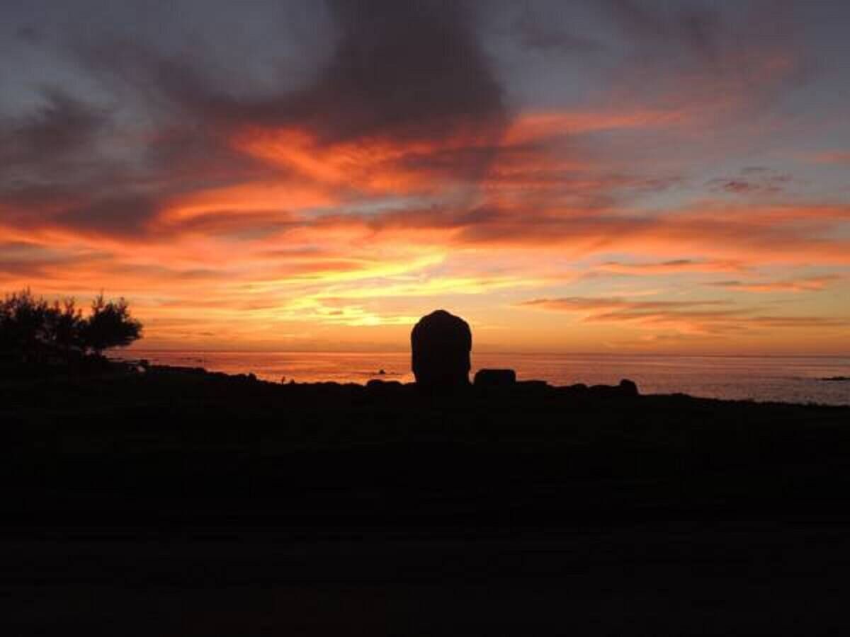 A silhouette of a building against a sunset sky.