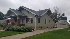 A two-story house with a gabled roof, a brick chimney, and a garage. - LOFT in Sanborn (Sanborn)