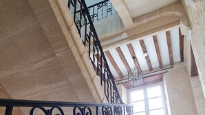 A staircase with ornate black railings and a stone wall. - Elegant Manor with in Normandy by the sea - 8 rooms for 22 persons. Pool and spa (SULLY)