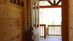 A wooden interior with a door leading to a wooden deck. - New cabin with king size bedrooms, en suite bathrooms, smart TV, decks & views. (Fairview)