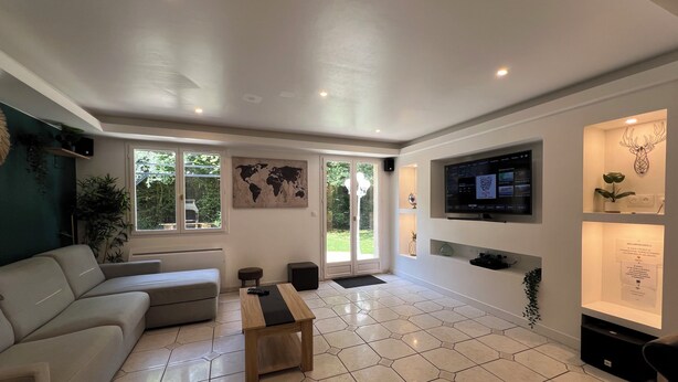 A modern living room with a sofa, a coffee table, a TV mounted on the wall, and a world map on the wall.