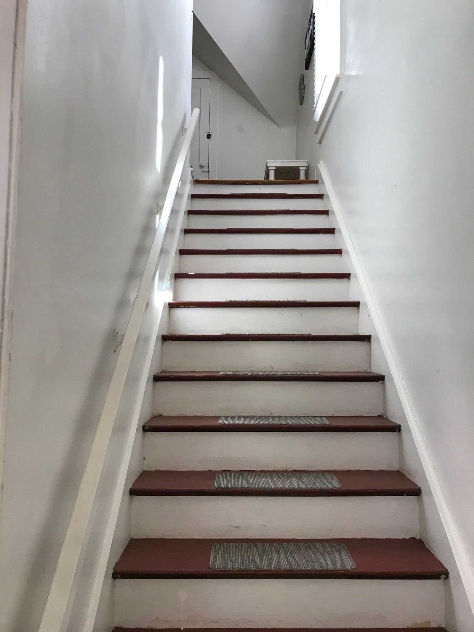 A staircase with white walls and wooden steps.