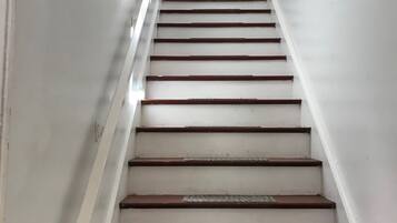 A staircase with white walls and wooden steps.