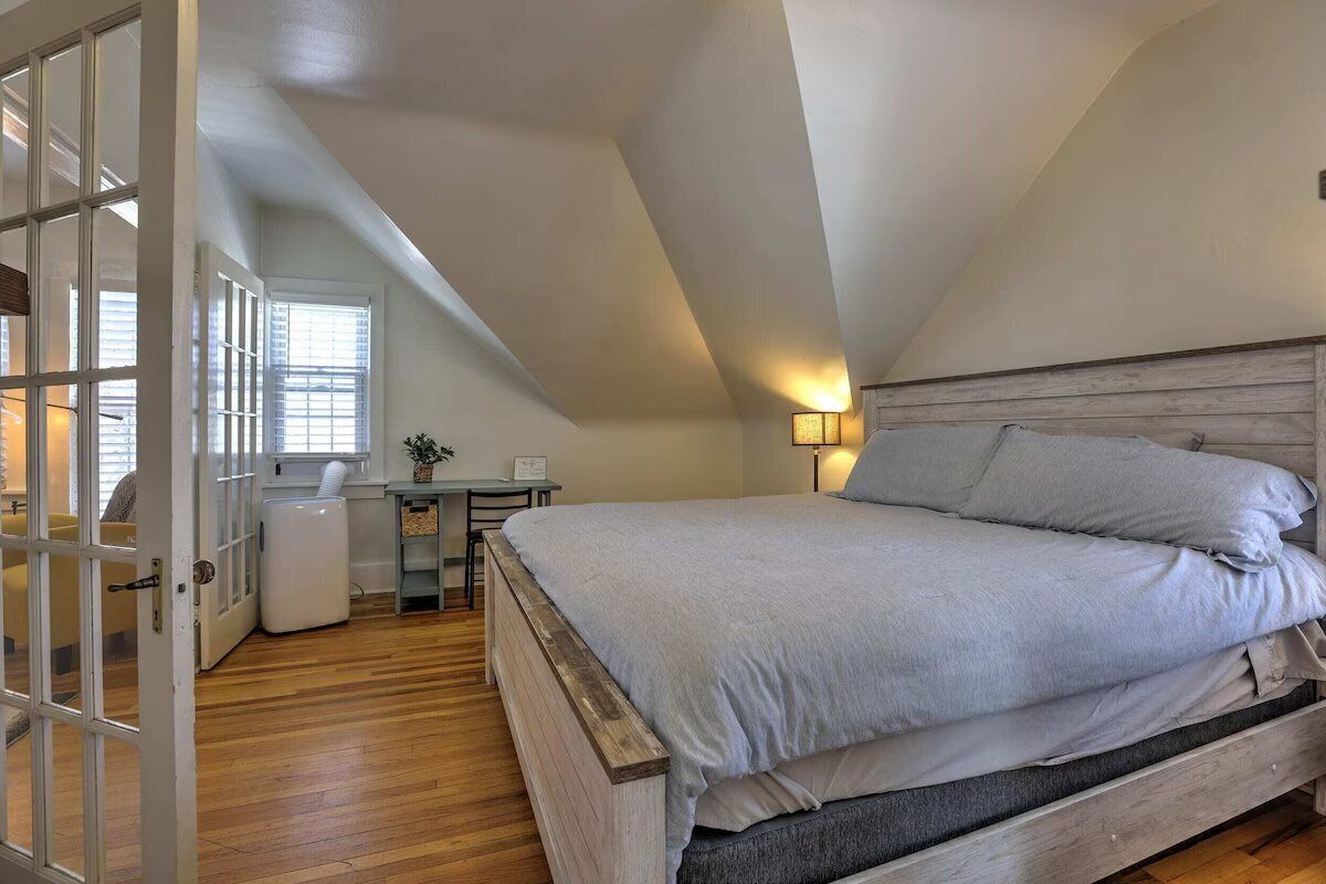 A bedroom with a wooden bed, a desk, and a chair.